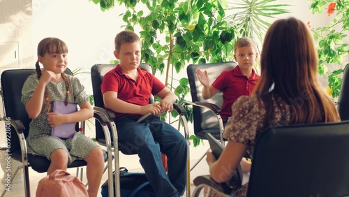 Involved little children answer teacher questions resting in extended day group