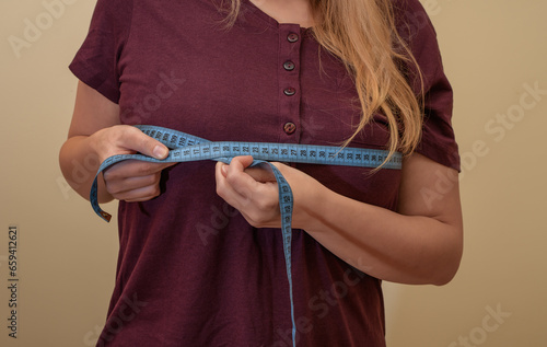 Kobieta mierzy obwód klatki piersiowej na wysokości biustu