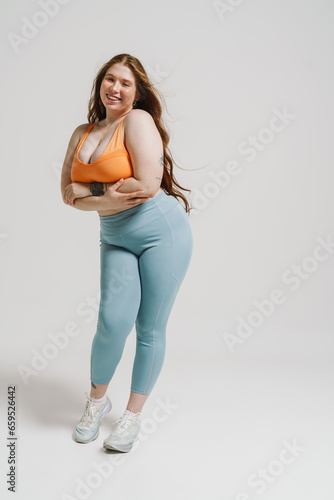 Beautiful plus size woman smiling while posing isolated over white background