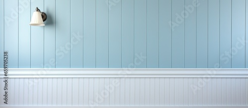 Silver hooks on white wainscoting against light blue walls with no items hanging