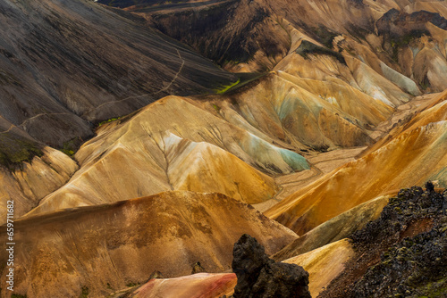 Multicolored mountains seen in Landmannalaugar, a location in Iceland's Fjallabak Nature Reserve in the Highlands, an area known for its natural geothermal hot springs and surrounding landscape.