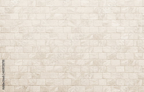 Empty background of wide cream brick wall texture. Beige old brick wall concrete or stone textured, wallpaper limestone abstract flooring. Grid uneven interior rock. Home decor design backdrop.