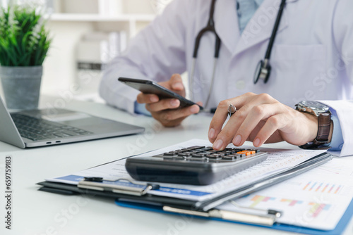 Doctor physician calculate medical healthcare fee costs and revenue, Practitioner using calculator at Clinic.