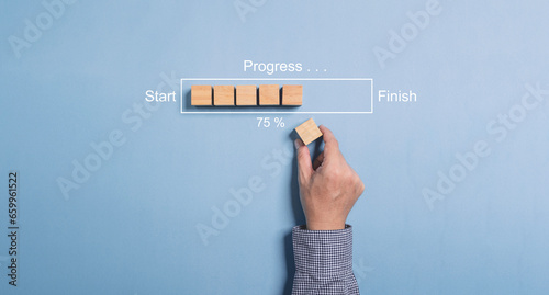 Hand putting wooden cube on virtual infographic rectangle block with progress wording and update status since start to finish fpr Job progressive concept.