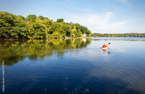 A Kayaker takes to the water on a warm October morning on a lake in Wisconsin.