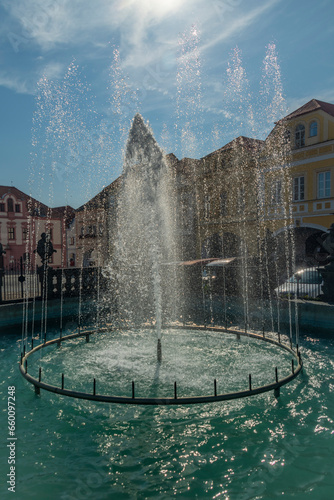 Old square with blue sky and fountain in sunny day in Kadan