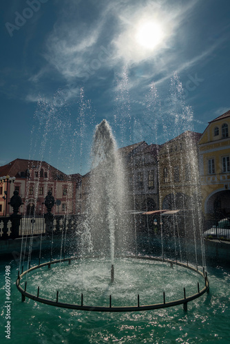 Old square with blue sky and fountain in sunny day in Kadan