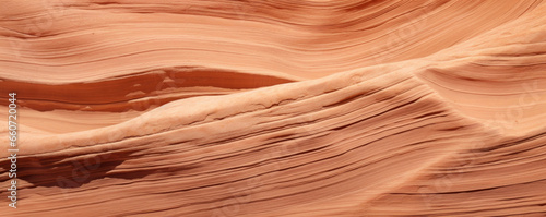 A detailed view of sandstone with deep ripple patterns, resembling the carved grooves of a canyon wall. The stones surface has a sculpted, almost sculptural quality to it.