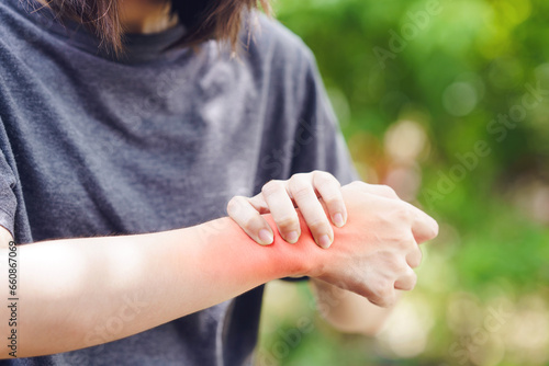 A woman grips her wrist due to a sprain causing inflammation and pain.