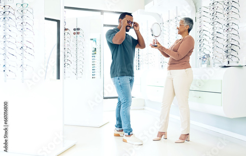 Mirror, glasses and optician help happy man in store for choice of lens, frame and consultation. Smile, reflection and mature optometrist with patient for spectacles, healthy vision and ophthalmology