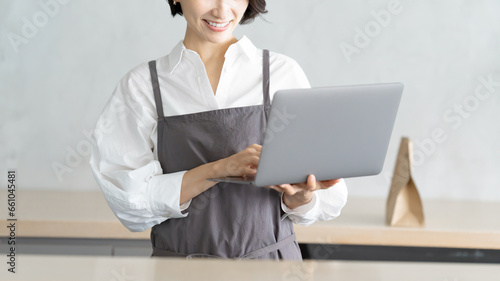 パソコンで注文を確認するカフェ店員