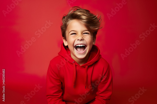 Photo of caucasian happy boy in red clothes over red background