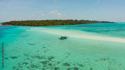 Tropical landscape with a beautiful beach in the blue water and an island with coral reef and atoll. Mansalangan sandbar, Balabac, Palawan, Philippines. Summer and travel vacation concept