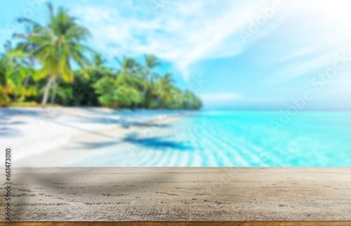 Wooden table top on blur blue sea and coconut leaf background in summer season.For place food,drink or health care business.fresh landscape and relax season concept.View of copy space.