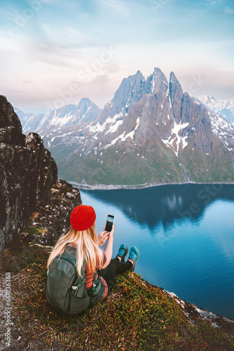 Woman blogger taking photo by smartphone of mountains and fjord landscape in Norway tourist girl traveling hiking with backpack summer vacations healthy lifestyle outdoor