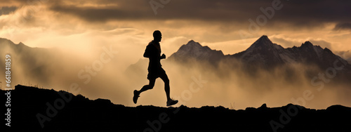 Trail runner nature landscape running man silhouette on mountains background in cold weather with clouds at sunset. Amazing scenic view of peaks in altitude.