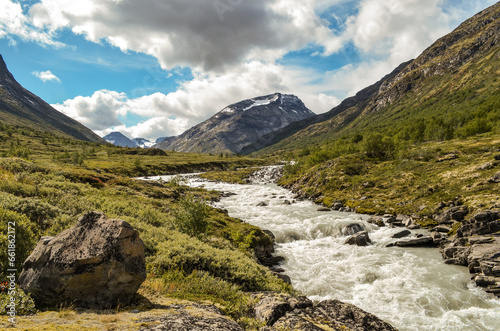 Wild river in the Jotunheimen National Park in Norway with mountain Styggehoe in the background - way to the Spiterstulen settlement