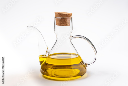 Typical oil jug with gold-colored virgin olive oil, white background.