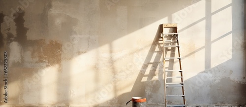 Ladder construction equipment in empty room illuminated by sunlight shabby wall with holes and stains ready for apartment renovation With copyspace for text