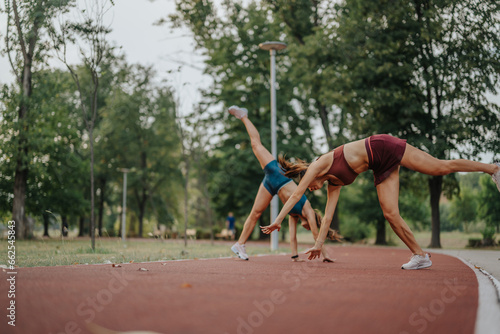 Fit girls performing 360-degree cartwheels in a green outdoor setting. Inspiring athletes showcase stamina and strength in nature. Ideal for sports and healthy lifestyle concepts.