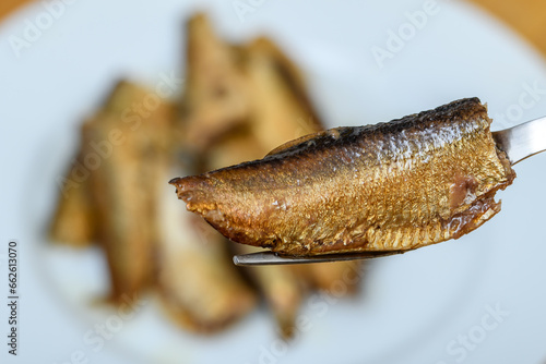 Ryba wędzona szprotka na widelcu