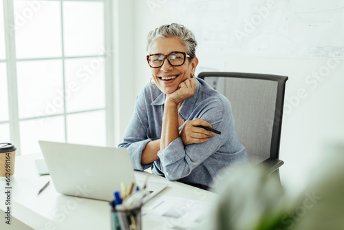 Success in a design career: Senior woman creating graphic designs at her desk