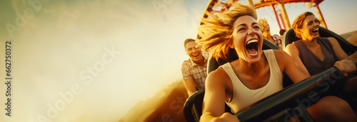 People cheering and enjoying a roller coaster ride at the amusement park with sunset in the background. With copy space. 