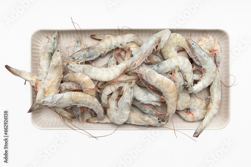 A dish with frozen shrimp isolated on a white background. Fresh shrimps are laid out on the table. Products for grilling. Frozen shrimp.