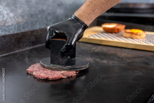 manufacturing and cooking process of homemade meat burgers on an iron plate with chedar cheese and pan bread and wrapping