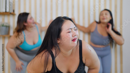 Group of plus size woman friends feeling tired during doing aerobics exercises together. Chubby woman friends feeling exhausted after training workout. Healthy lifestyle concept