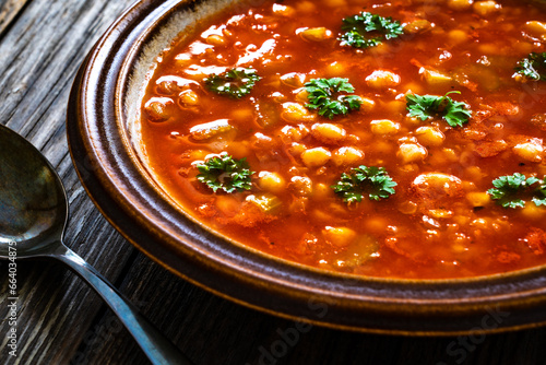Moroccan cuisine - harira fresh vegetable soup with chickpeas and lentil on wooden table 