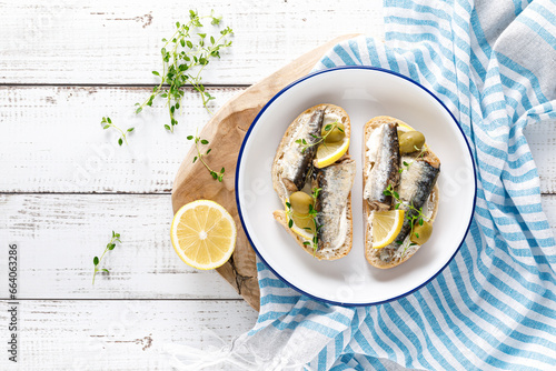 Sardines sandwiches on a white wooden background. Mediterranean food. Top view