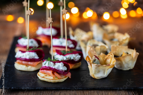 Christmas canapes with blinis with salmon, beetroot and goat cheese and filo pastry cups