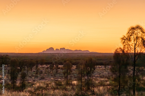 Sunset over australian outback in Northern Territory Australia, with Mount Olgas at background.