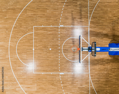 Top view of a basketball hoop and the restricted area (the key) with a foul line (free throw lane) on a parquet basketball court