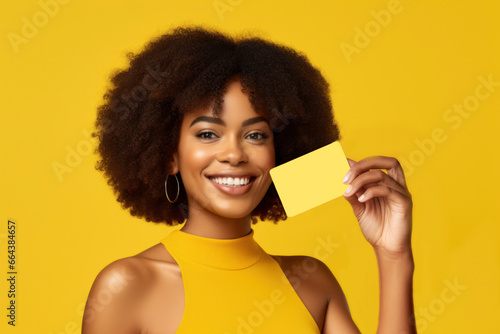 Winking woman holding credit card with hand isolated on yellow colored background. AI Generative