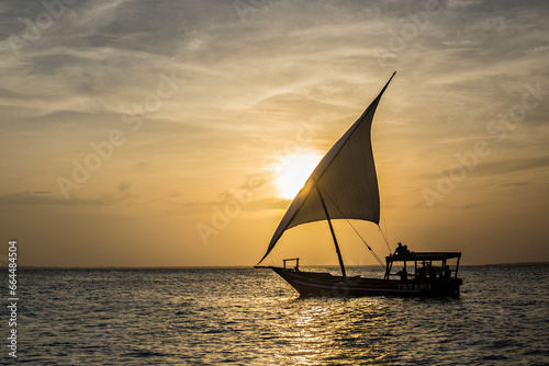Traditional Zanzibar dhow at sunset. Sunset sky and the dhow in the sea at Zanzibar, Tanzania