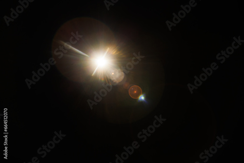 Easy to add lens flare effects for overlay designs or screen blending mode to make high-quality images. Abstract sun burst, digital flare, iridescent glare over black background.