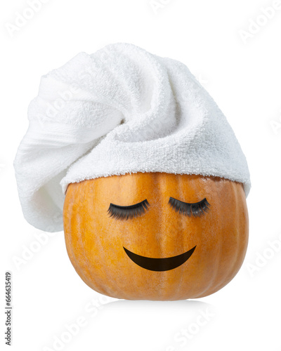 Pumpkin with cosmetic mask and eyelashes in a towel