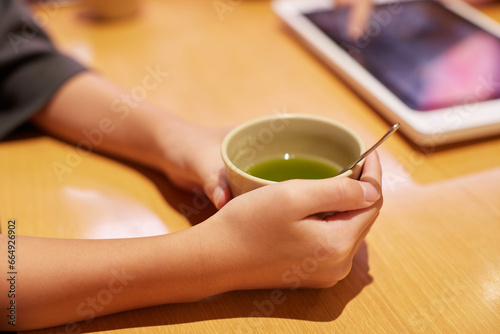 喫茶店でお茶を飲みながら注文する女性の手のアップ写真