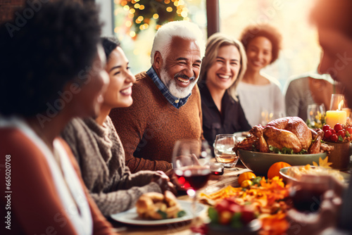 A multi generational and racial family having a traditional Thanksgiving dinner talking and sharing food with happy and grateful for the meal, a large full turkey in the centerpiece of the table