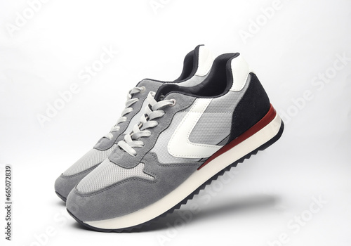 Pair of gray running shoes levitating on white background