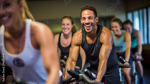 Portrait of smiling man on exercise bike with friends in gym