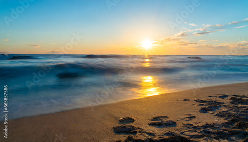 ocean sunrise over beach shore and waves the sun is rising up over sea horizon