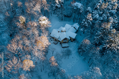 Aerial view of an old manor house hidden among a fabulous snow-covered forest in winter. The Turliki estate of 1901 - dacha Morozovoy. Obninsk, Russia