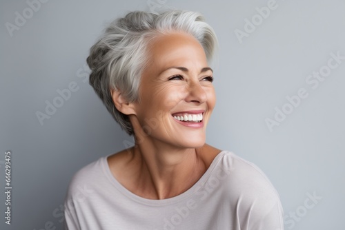 Beautiful gorgeous 50s mid aged mature businesswoman looking away isolated on gray. Mature old lady close up portrait. Healthy face skin care beauty, middle age skincare cosmetics.