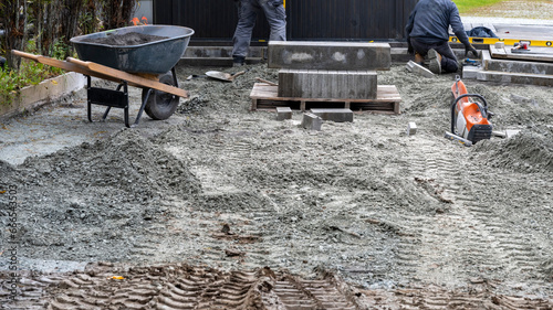 Workers placing cement blocks for a patio floor
