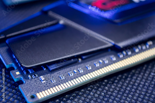 Memory module DDR4 DRAM with electrical contacts in blue light. Computer RAM chipset close-up. Desktop PC hardware components