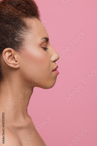 Beautiful young woman with glamorous makeup on pink background