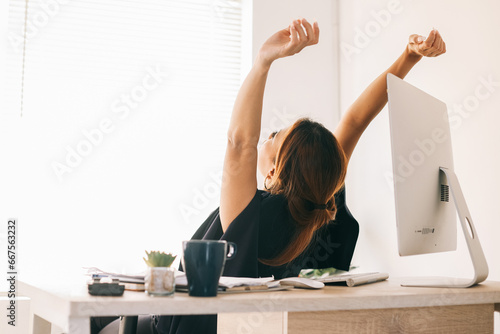 Rear view of Asian business woman stretching and relaxing from work